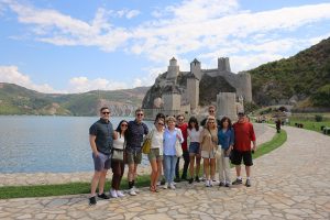 Group of people are posing in front of the Golubac fortress on Iron Gate gorge tour.